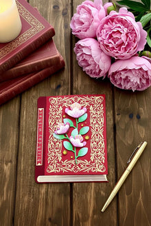Red Book Pink Florals card flat on dark walnut with pink peonies and candlelight